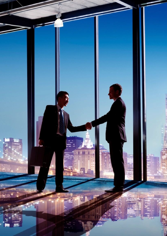 Two men shaking hands in front of a window.